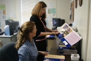 Lindsay Darling, a second-year law student, and Regan Bruni (standing), New Student Orientation coordinator, assemble information packets for the more than 400 prospective students and parents expected to take part in Saturday\'s (Sept. 30) open hous