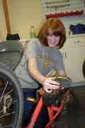 Sarah Lovell, a senior computer engineering and biometric systems major and a Tau Beta Pi member, repairs one of the bikes that was donated last fall during the engineering honor society\'s community bike drive. Tau Beta Pi, along with Positive Spin,