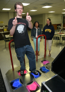 Andrew Bosley, a junior electrical engineer from Ridgeley, shows off his best moves on the Mountainlair\'s new Dance Dance Revolution (DDR) video game for Christina Friend, a senior public relations major and Cassie Grizzell, a senior majoring in mul