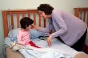 Dr. Hawley Montgomery-Downs applies electrodes to Bryn Tronco before the youngster gets under the covers for the cause at WVU\'s Sleep and Sleep Disorders lab. Montgomery-Downs\' most recent study shows that youngsters who were breast-fed babies
