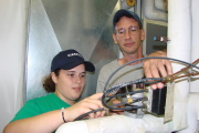 Cayla Hefner, apprentice, works with her mentor on heating and cooling unit.