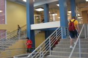 Photo of the stairwell at the Mountainlair. Shows students walking up and down steps and new gold and blue paint job.
