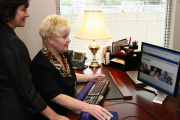 Trisha Gyurke, director of WVU Employment Services, seated, and Dual Career Program Coordinator Rose Chavez-Uncapher review a new Human Resources website designed to market the program geared toward professional couples.