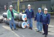 From left, Terry Wells and Peter Stansberry (both from GrafTech), Al Stiller and Elliot Kennel (WVU chemical engineering researchers) inspect four of 21 graphite electrodes that were made using synthetic binder pitch produced from coal at WVU. Chemical en