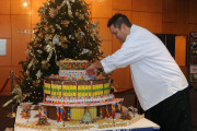 Eric Filburn, executive chef with WVU catering, puts the finishing touches on a gingerbread house of the West Virginia University Creative Arts Center. The tasty work of art is on display in the CAC's main lobby. 