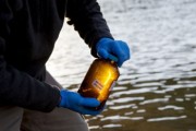 Brady Gutta, from West Virginia Water Research Institute, seals a water sample collected from the Elk River in Charleston, WV.