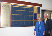 Karen and Dr. James Caveney beside the WVU Wall of Academic Scholars.